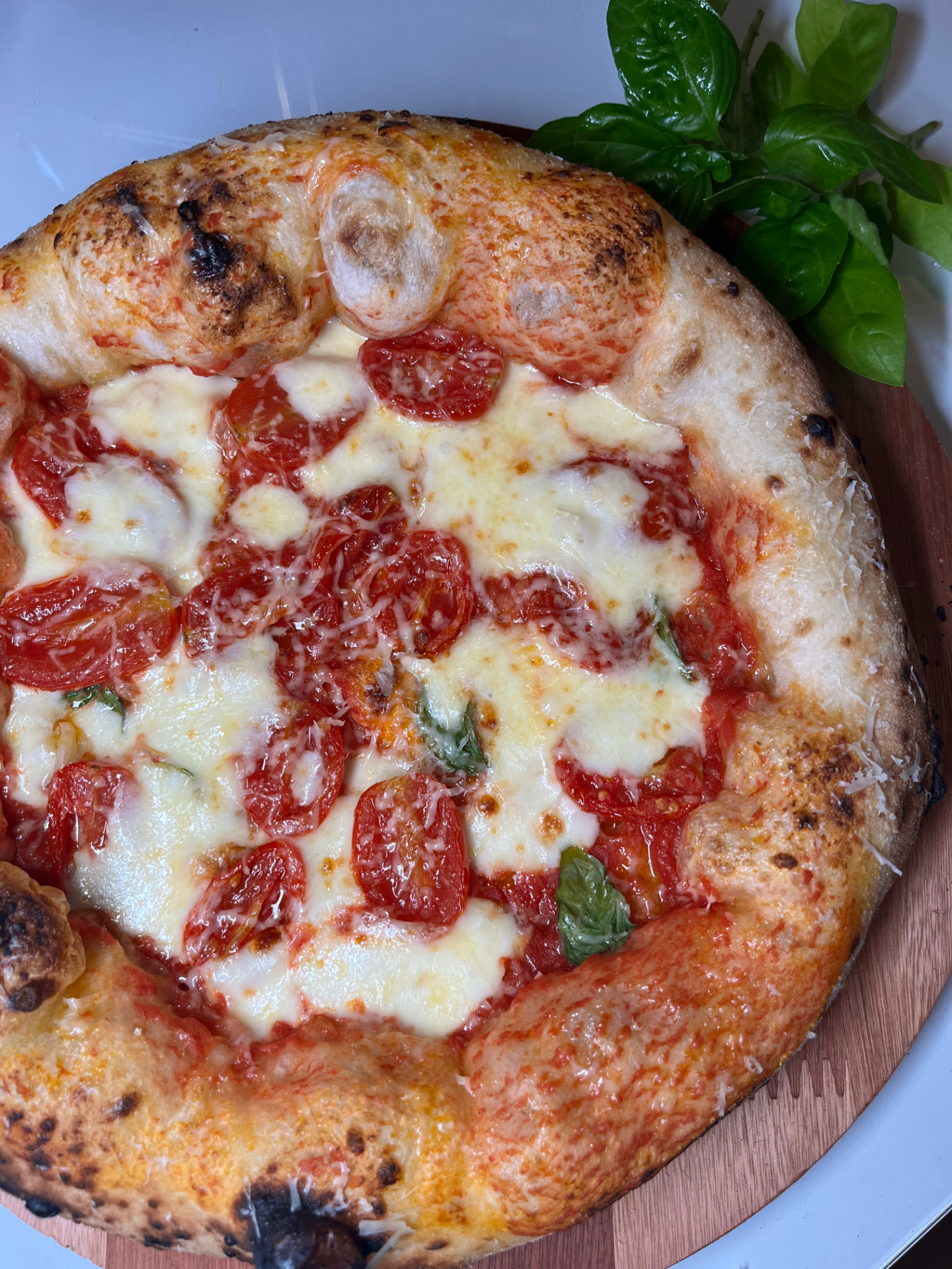 Pizza artesanal de longa fermentação com tomate, muçarela e manjericão fresco, assada ao vivo pela Paollo Pizza